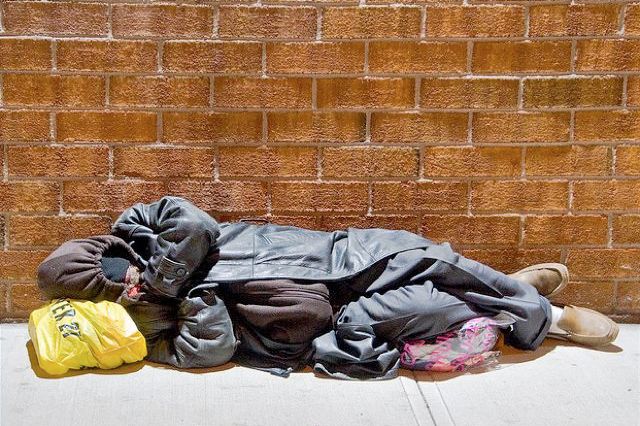 In this file photo, what appears to be a homeless person sleeping on a sidewalk is really just an OPTICAL ILLUSION.